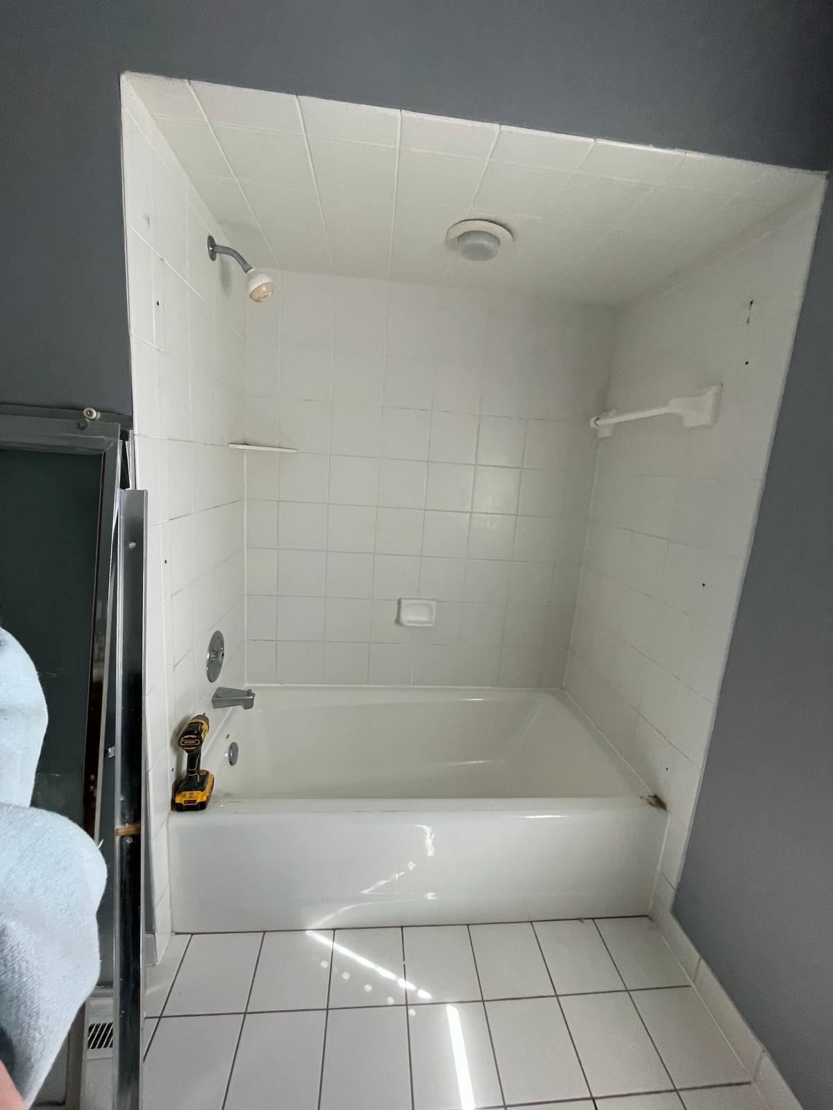 Old white tile tub surround before demo
